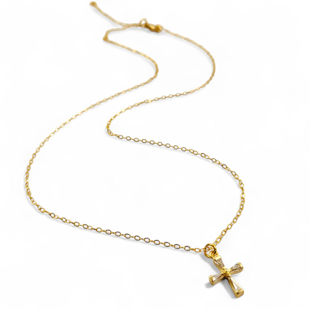Gold necklace with a cross pendant on a white background