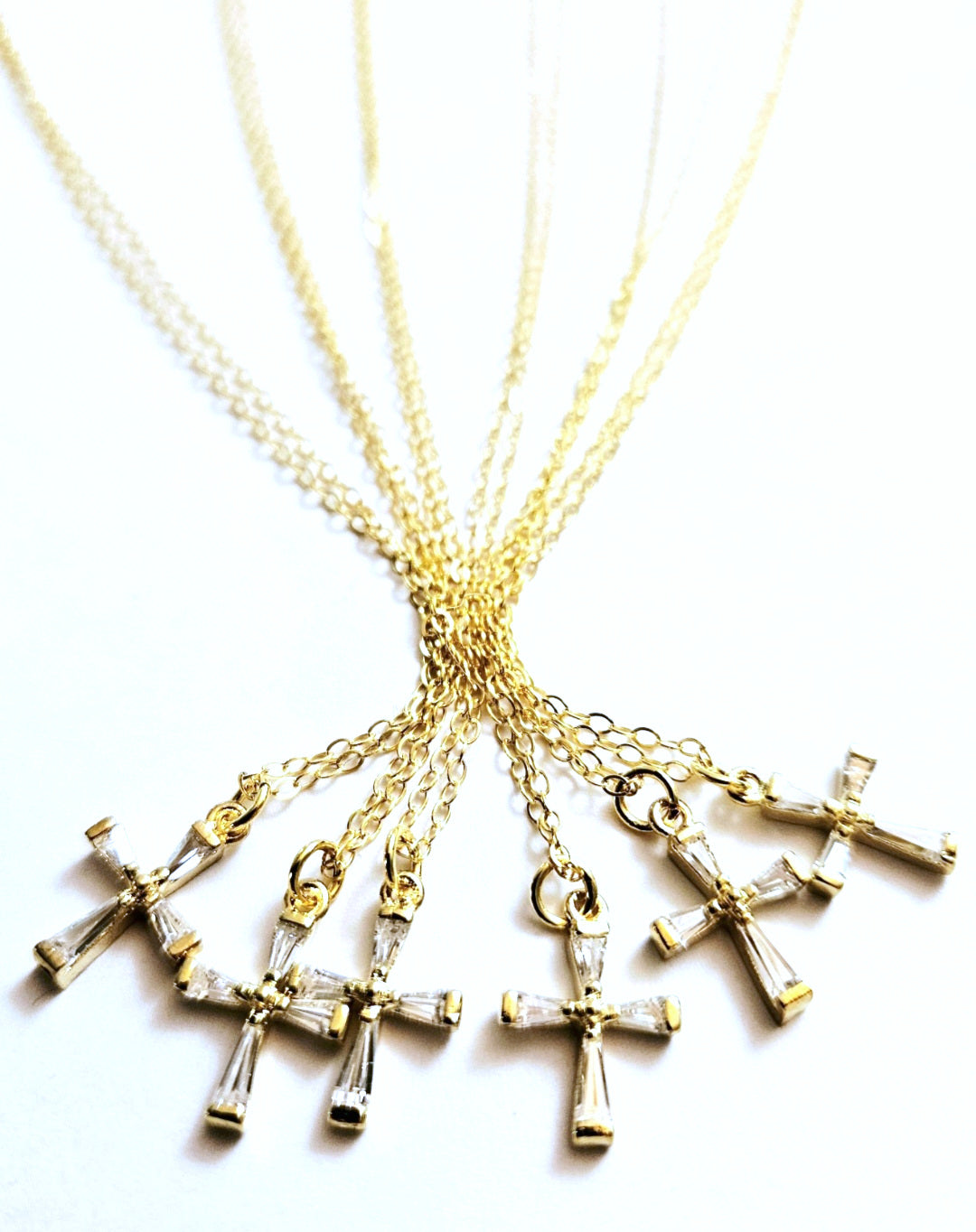 Gold cross necklaces on a white background